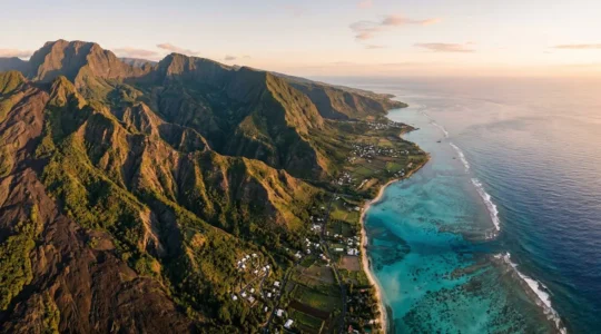 Vue aérienne grand angle montrant la diversité des paysages de La Réunion avec cirque verdoyant, volcan et lagon turquoise