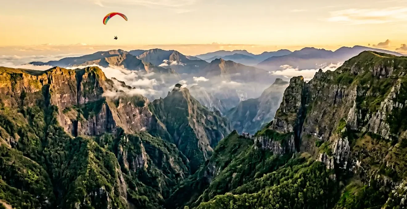 Vue aérienne spectaculaire des cirques volcaniques et remparts vertigineux de La Réunion avec parapentiste en vol