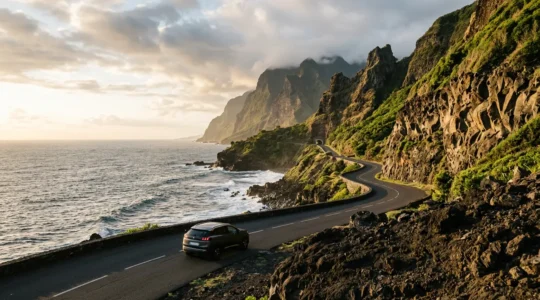 Vue panoramique de la route côtière de La Réunion avec une voiture au premier plan et l'océan Indien en arrière-plan