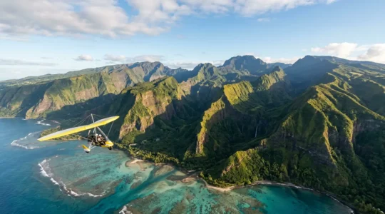 Vue aérienne d'un ULM pendulaire survolant le lagon turquoise et les cirques verdoyants de La Réunion