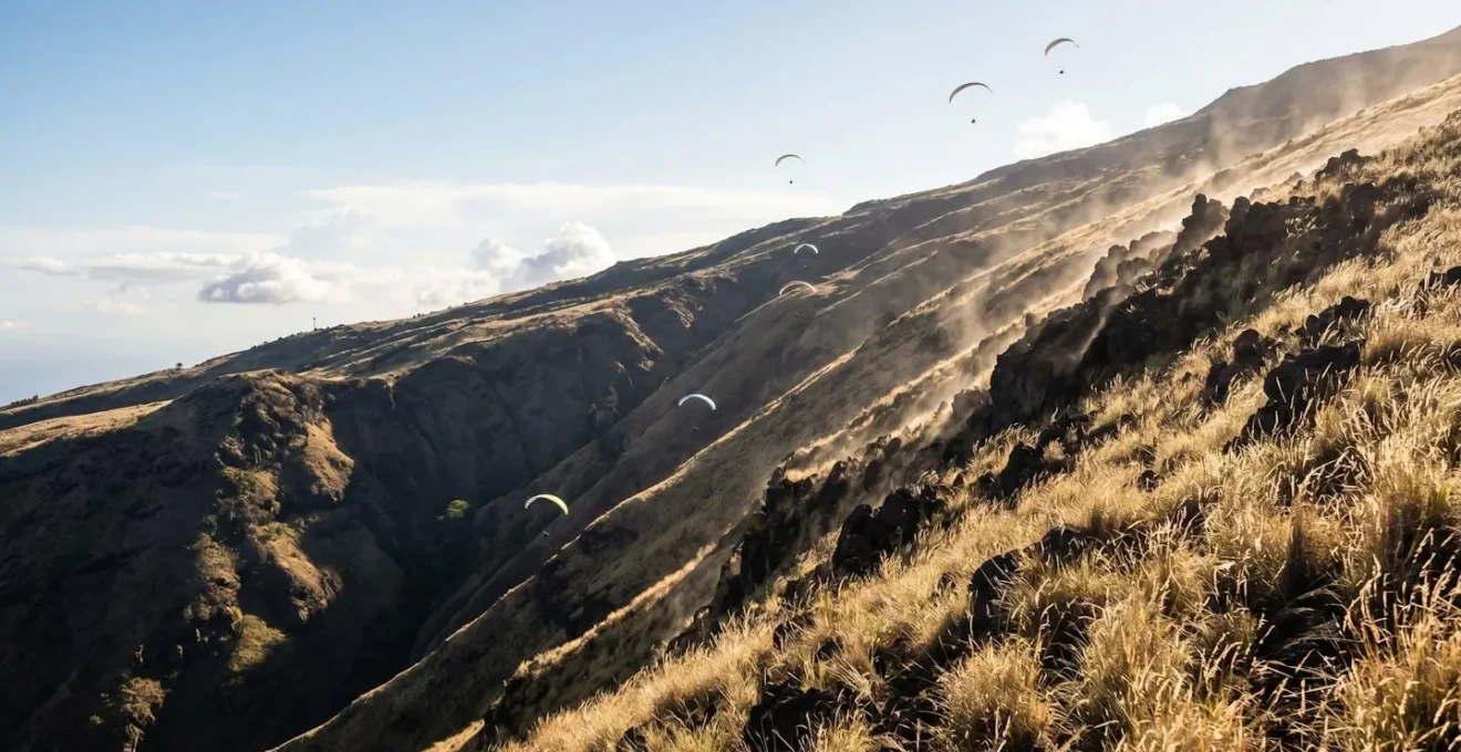 Schéma visuel montrant la formation de la brise thermique sur les pentes de Saint-Leu avec des parapentes évoluant dans les courants ascendants