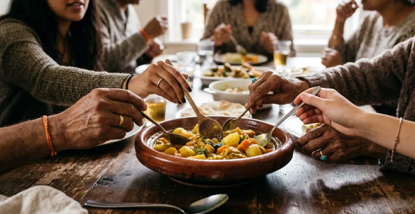 Différentes mains de couleurs variées partageant un repas créole autour d'une table commune